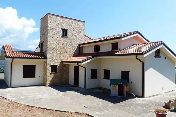 Two-story house with stone and tile roof