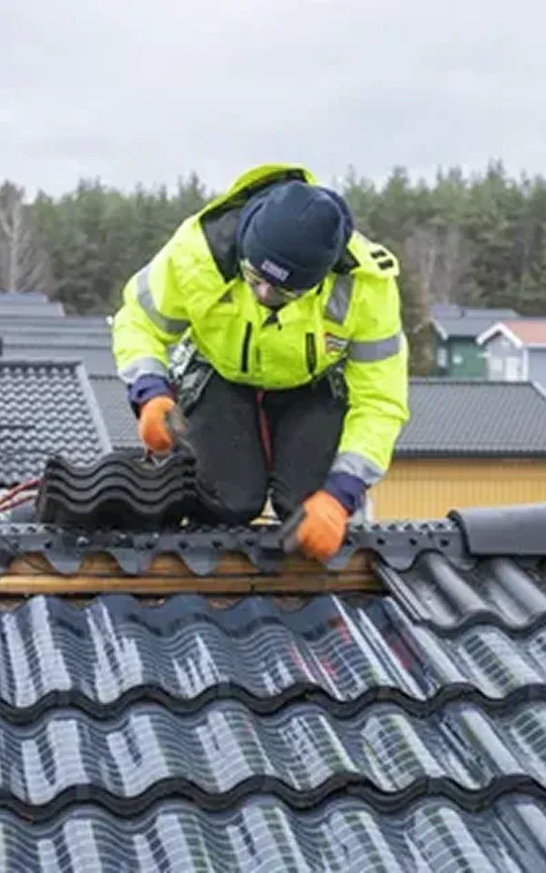 South Jersey Worker installing tiles on a roof, wearing safety gear