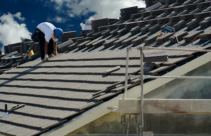 Livingston Worker installing tiles on a sloped roof