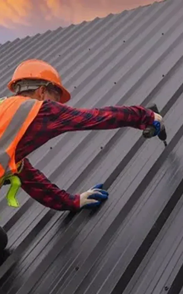 Lincoln Park Worker on a metal roof, using a power drill