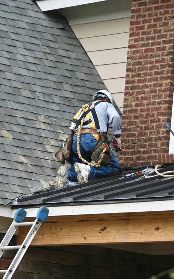 middlesex Worker on a roof using safety harness and tools