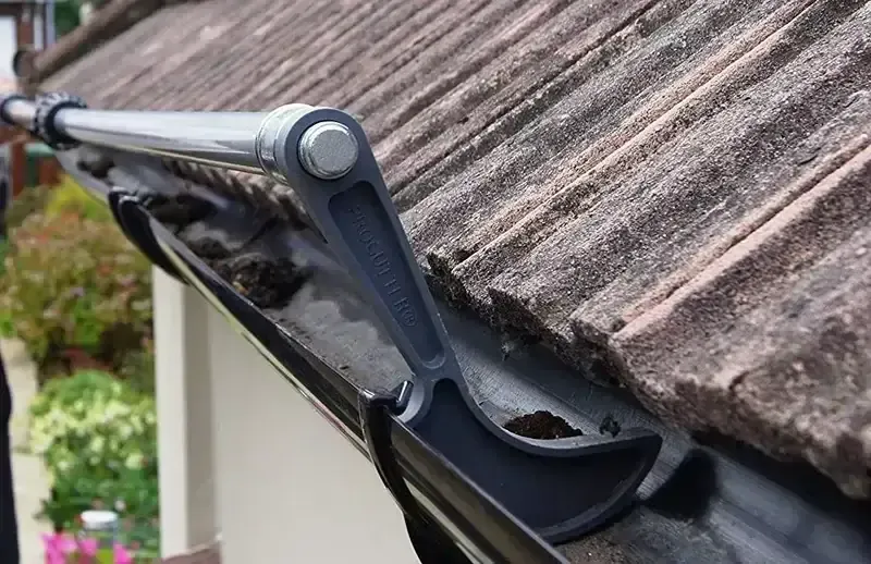 Warren Gutter cleaning tool positioned on a roof edge