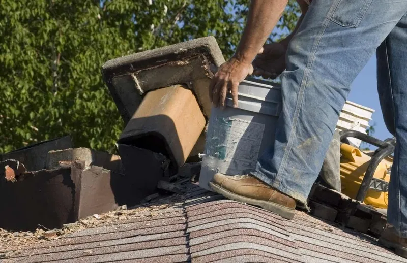 Person working on a roof, holding a bucket