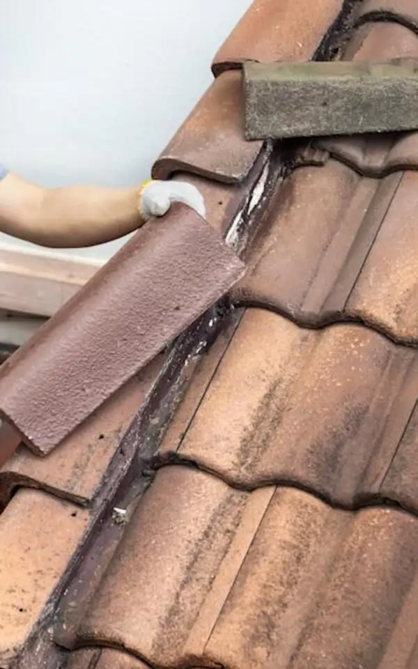 Roof tiles being adjusted or repaired with tools