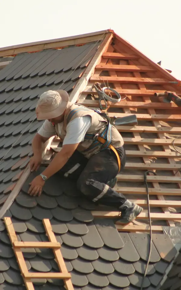 Roofer installing shingles on a sloped roof