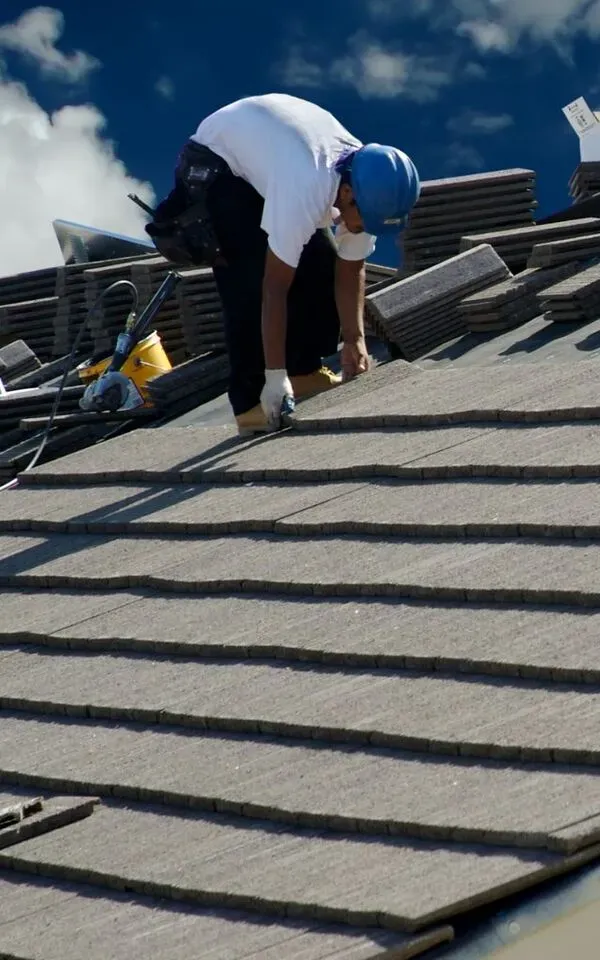 Worker installing roofing materials on a sloped surface