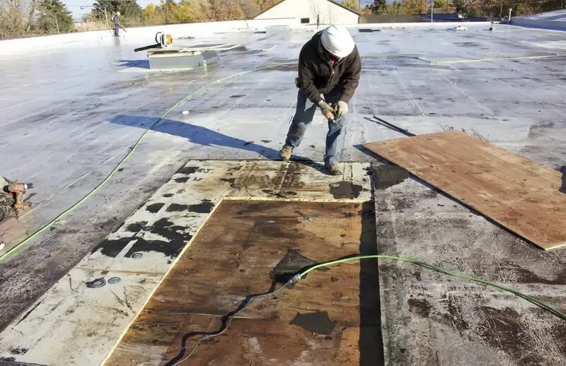 Worker repairing a roof with wooden boards
